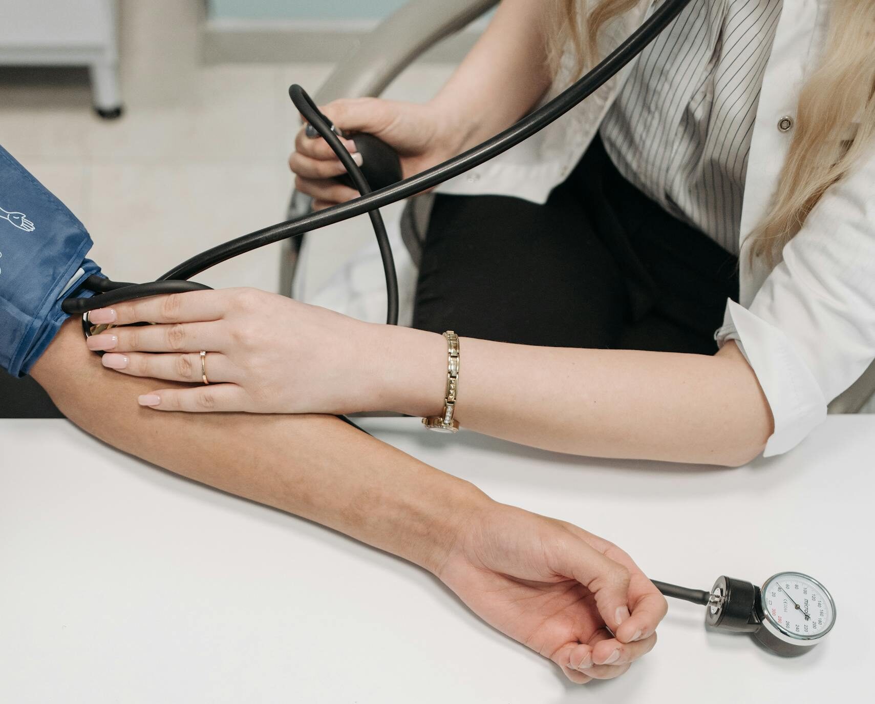 A medical practitioner checking a patient's blood pressure in a clinical setting.